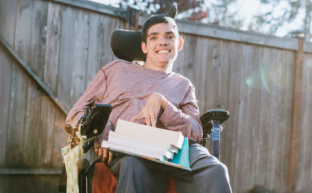 Photo of a young man in a wheelchair smiling