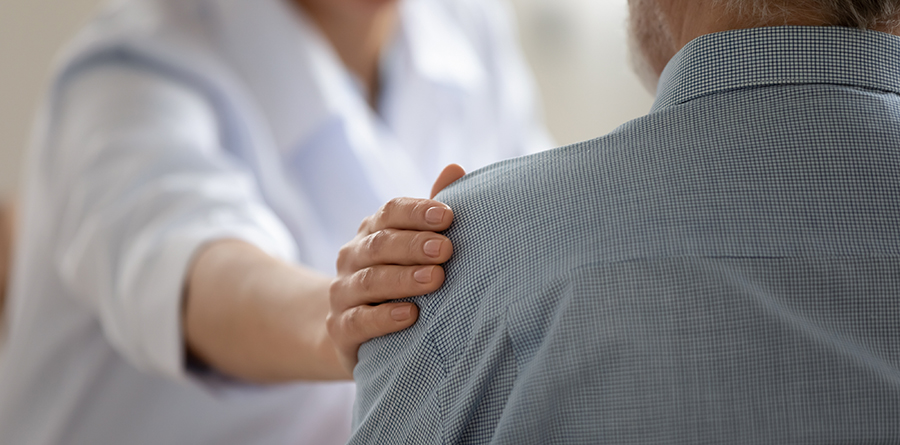 person putting a hand on the shoulder of another person